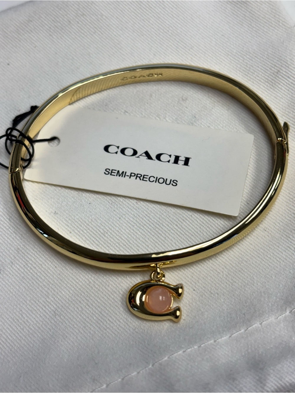 Coach Gold-Tone Bangle with Pink Stone Charm